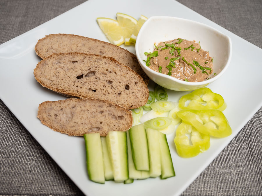 Vegán kenőmájas szeletelt kenyérrel és zöldségekkel tálalva