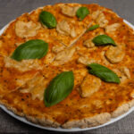Gluténmentes Margherita pizza bazsalikommal, szeletelve, fehér tányéron