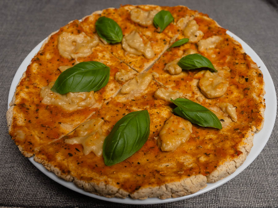 Gluténmentes Margherita pizza bazsalikommal, szeletelve, fehér tányéron