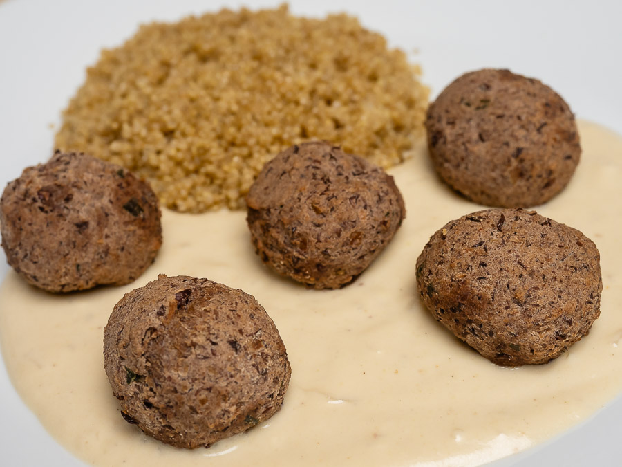 Adzuki babos vegán svéd húsgolyók barna mártással és quinoa körettel egy fehér tányéron