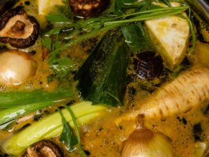 Vegán zöldségalaplé házi készítésű gyökérzöldségekkel shiitake gombával és póréhagymával főzés közben