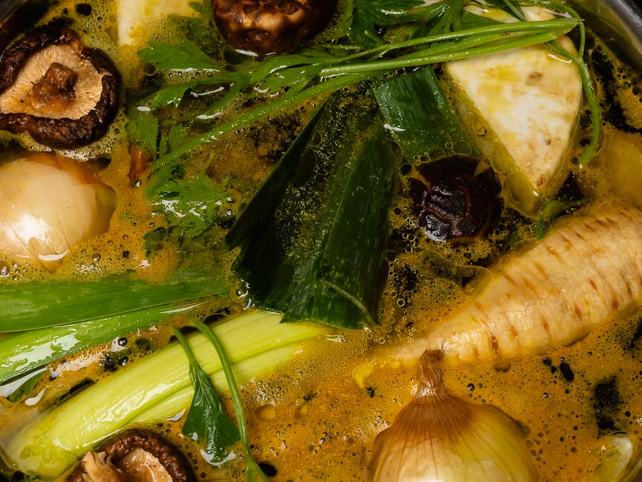 Vegán zöldségalaplé házi készítésű gyökérzöldségekkel shiitake gombával és póréhagymával főzés közben