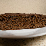 Egy szelet gluténmentes csokis piskóta fehér tányéron