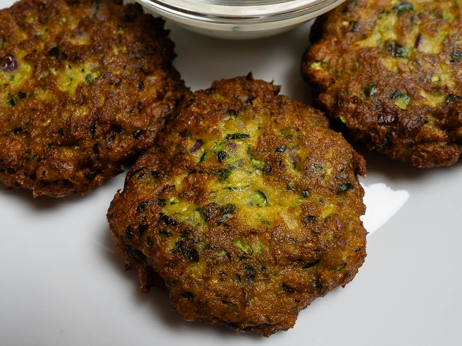 Aranybarnára sült görög cukkini fasírt közelről friss zöld fűszerekkel és ropogós textúrával