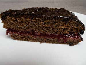 Gluténmentes Sacher torta szelete erdei gyümölcsréteggel