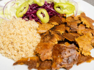 Vegán döner tányéron pirított tofu szeletekkel és friss zöldségekkel