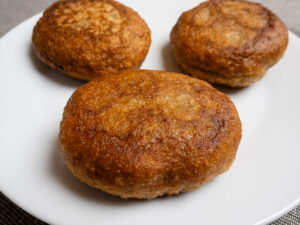 Gluténmentes farsangi fánk aranybarnára sütve fehér tányéron töltés előtt